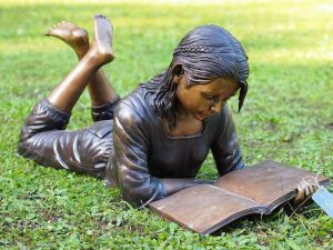 Tuinbeeld - bronzen beeld - Liggend lezend meisje - 45 cm hoog